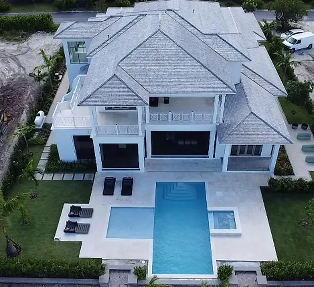Aerial view of a completed Aquatech swimming pool and spa beside a modern two storey Bahamian residence